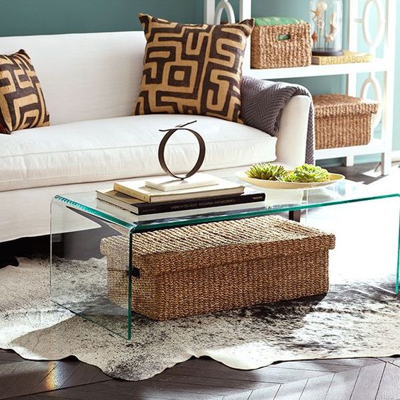 A-clear-glass-table-with-a-large-woven-box-with-a-lid-under-it-it-can-be-used-for-storage-without-cluttering