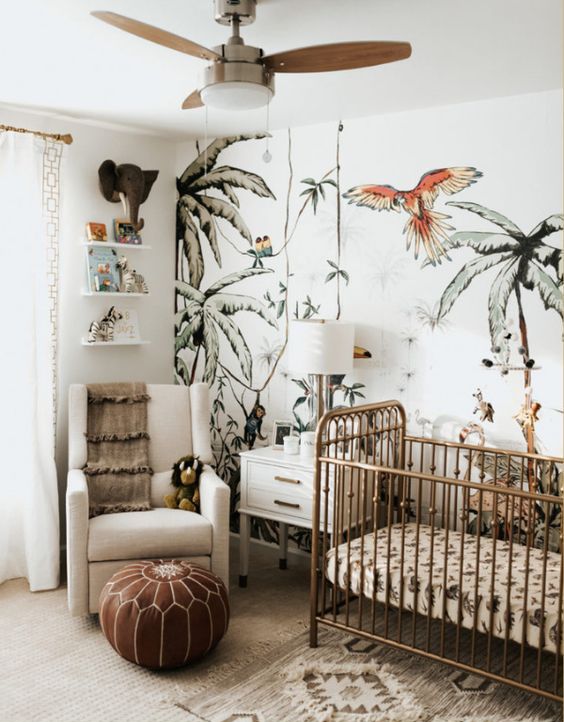 A-jungle-themed-nursery-with-a-fun-printed-wall-tropical-bedding-a-leather-ottoman-cute-jungle-themed-toys