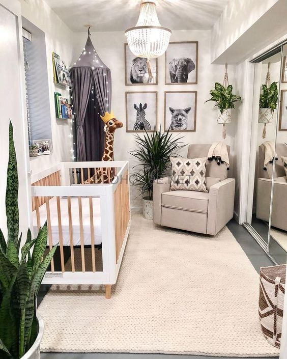 A-jungle-themed-nursery-with-black-and-white-artworks-potted-plants-a-light-canopy-and-printed-textiles