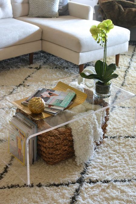 An-acrylic-coffee-table-with-a-basket-for-storage-and-some-books-under-the-top-is-a-cool-idea