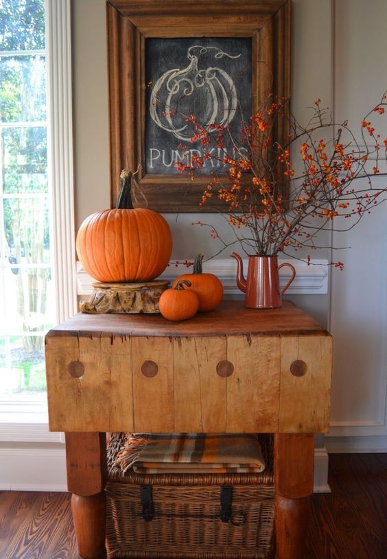 04-an-entryway-console-with-orange-pumpkins-some-branches-with-berries-and-a-wicker-chest