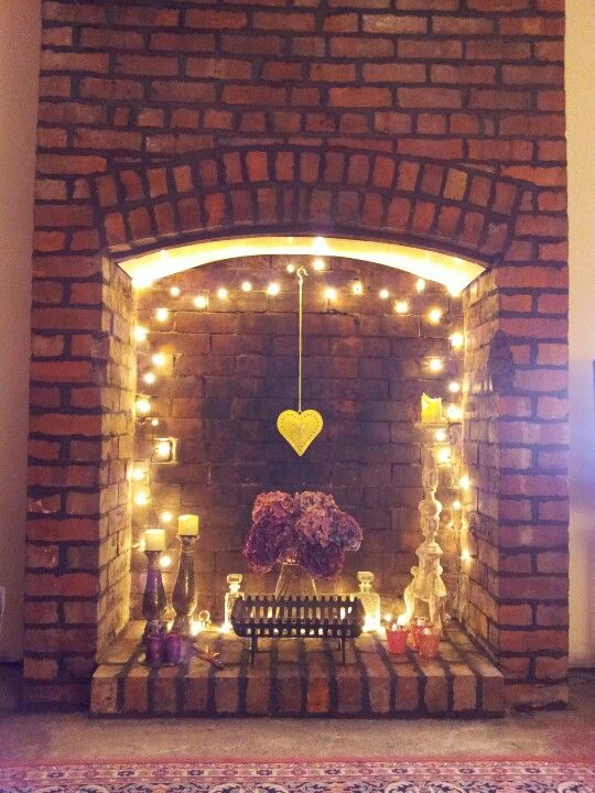 05-a-fireplace-with-string-lights-a-hanging-heart-and-some-candles-for-a-cute-look