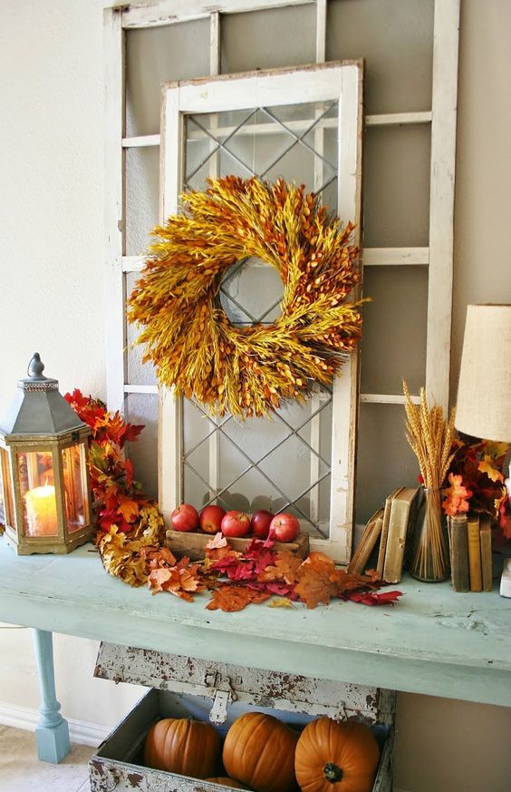 09-a-console-table-with-fall-apples-leaves-wheat-spikes-a-spike-wreath-and-some-pumpkins-under-the-table