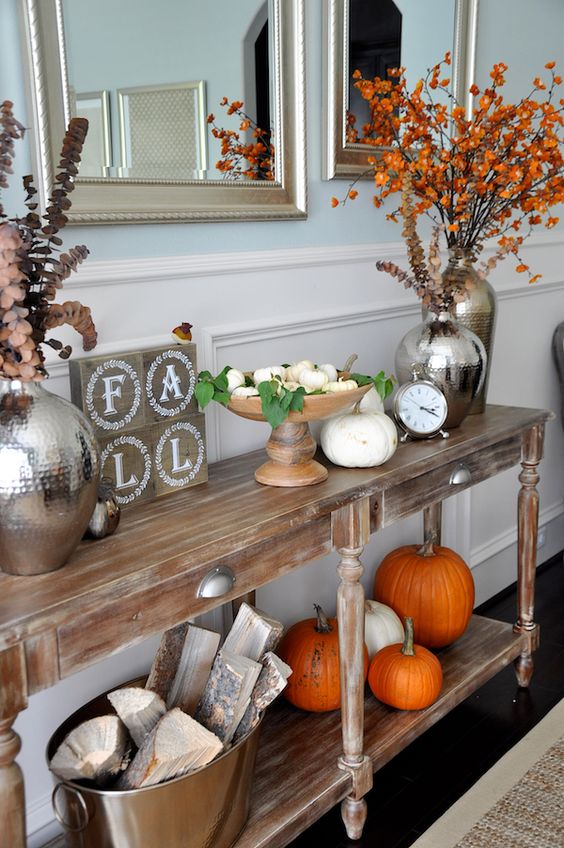 17-a-fall-console-with-orange-and-white-pumpkins-fall-leaves-and-dried-blooms-and-firewood-in-a-metal-bathtub