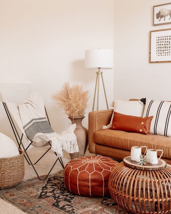 26-a-neutral-boho-space-with-a-tan-leather-sofa-and-a-rust-colored-ottoman-striped-textiles-pampas-grass-and-a-wooden-table