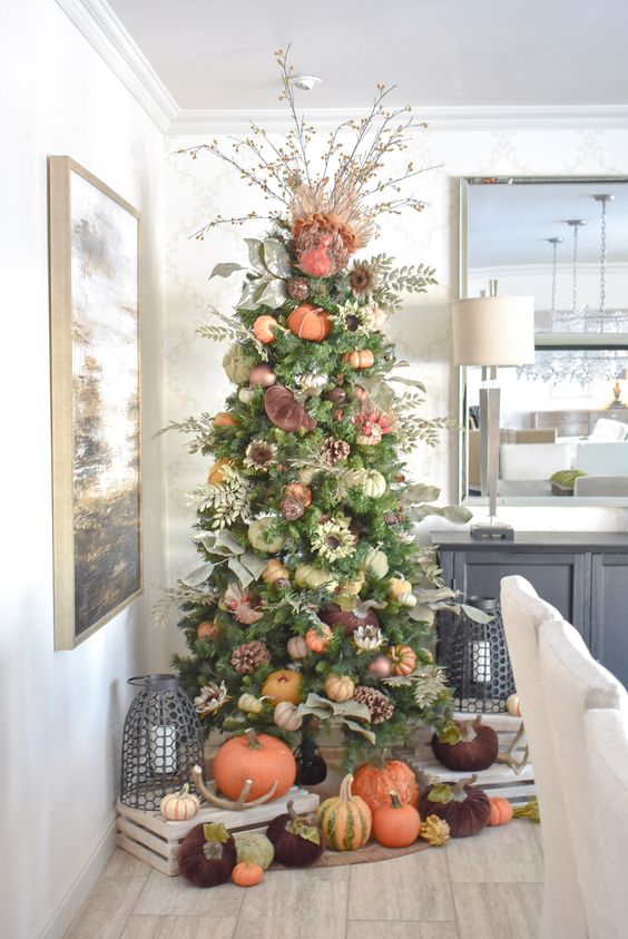 A-thanksgiving-tree-with-faux-and-velvet-pumpkins-pinecones-foliage-greenery-and-branches-with-berries-plus-more-pumpkins-under-it