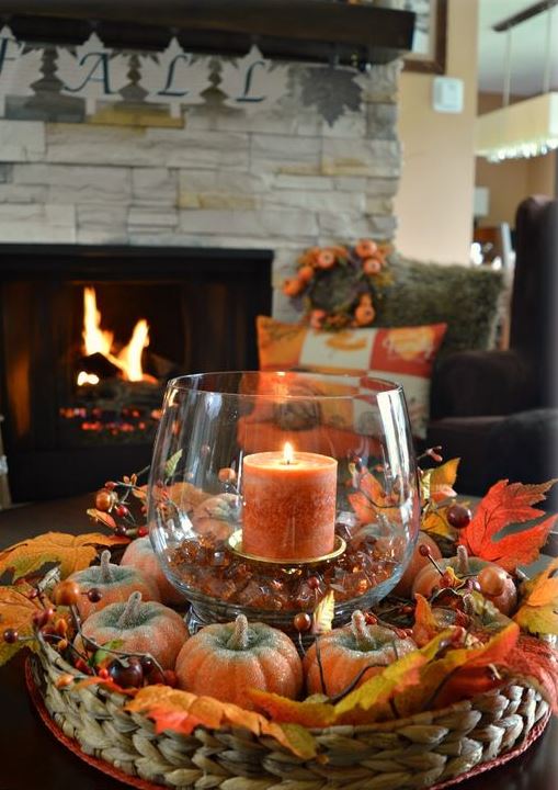A-basket-with-faux-pumpkins-and-berries-and-a-glass-with-a-candle-and-pebbles-for-the-fall