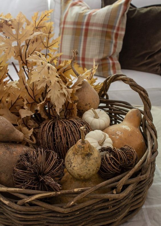 A-basket-with-vine-and-faux-pumpkins-pears-fall-leaves-and-gourds-is-a-rustic-decoration-with-a-strong-natural-feel