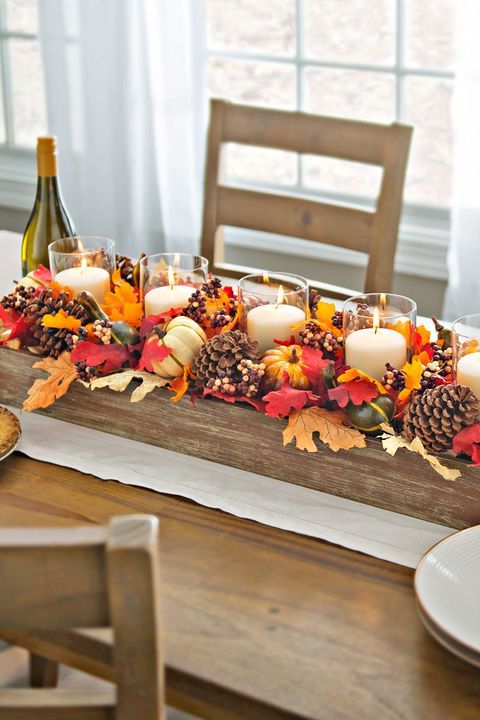 A-bright-fall-centerpiece-of-a-wooden-box-fall-leaves-acorns-gourds-and-pillar-candles-in-glasses