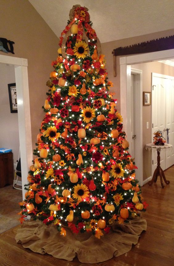 A-bright-fall-tree-with-lights-plaid-ribbons-faux-pumpkins-pears-sunflowers-and-a-red-bow-on-the-top