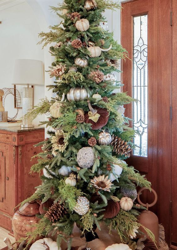 A-fabulous-thanksgiving-tree-with-white-silver-and-velvet-pumpkins-greenery-pinecones-antlers-and-some-more-pumpkins-under-it
