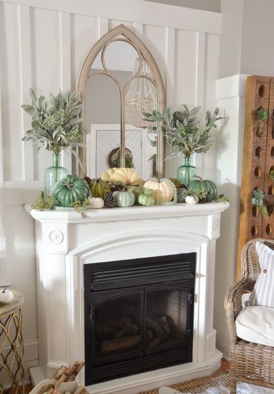 A-fall-mantel-decorated-with-pinecones-faux-pumpkins-pale-greenery-in-tall-bottles-1