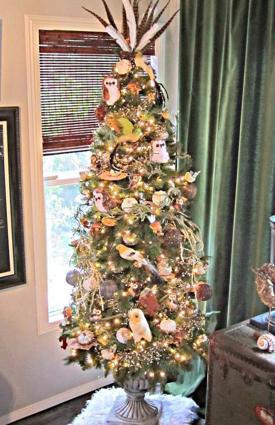 A-fall-tree-with-owls-lights-pumpkins-vine-balls-branches-ribbons-and-feathers-on-the-top