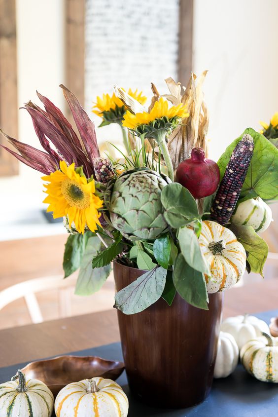 A-farmhouse-centerpiece-of-faux-blooms-husks-veggies-and-some-foliage-is-a-cool-fall-decor-idea