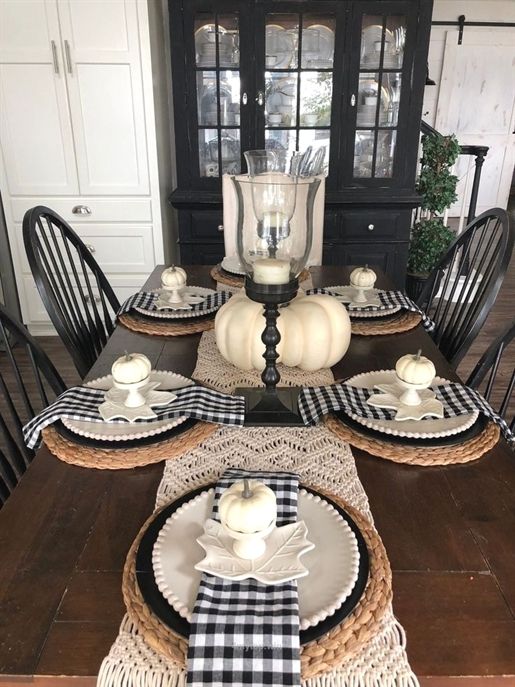 A-farmhouse-fall-table-setting-with-a-macrame-runner-woven-placemats-plaid-napkins-and-fake-pumpkins