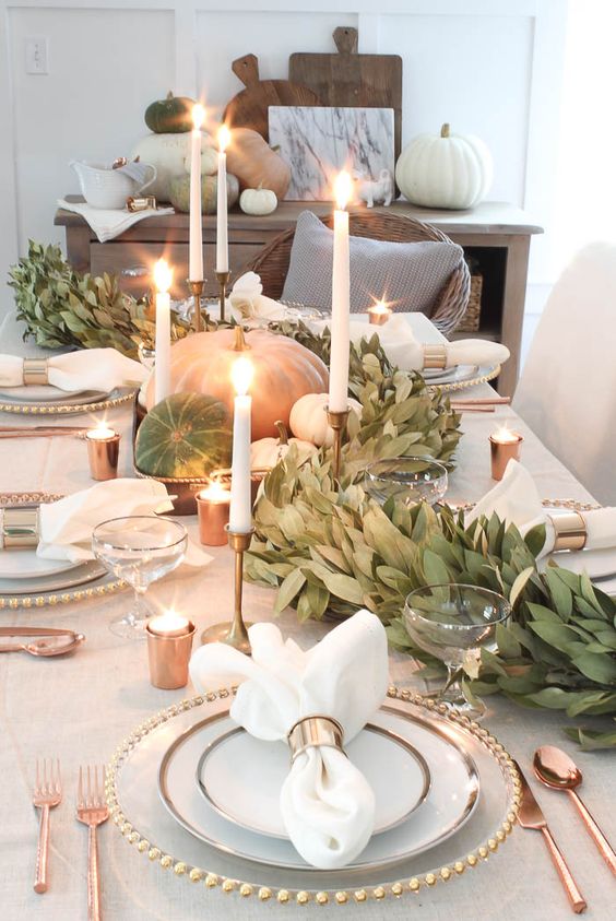 A-gorgeous-fall-table-runner-of-greenery-natural-pumpkins-and-white-candles