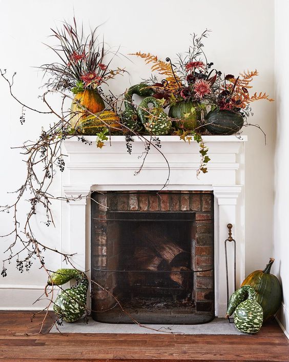 A-lush-harvest-mantel-decorated-with-greenery-long-branches-and-pumpkins-and-gourds-on-the-mantel