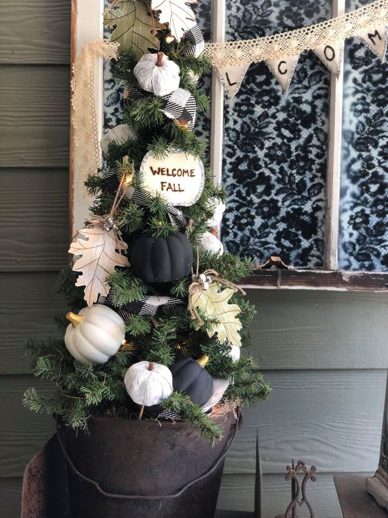 A-small-fall-tree-with-white-and-black-pumpkins-paper-leaves-a-plaid-ribbon-and-some-lights-can-fit-thanksgiving-too