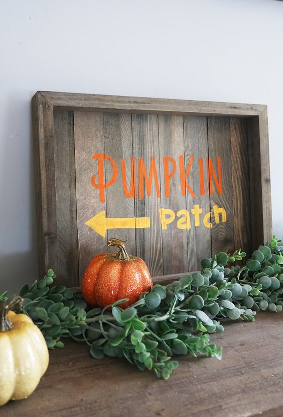 A-stained-fall-sign-with-colorful-letters-fresh-greenery-and-colorful-faux-pumpkins