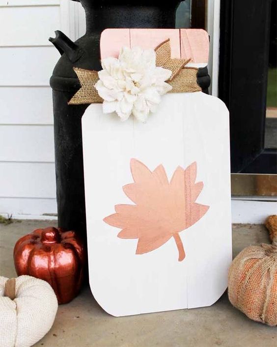 A-white-msaon-jar-with-leaf-fall-sign-with-a-burlap-ribbon-and-a-faux-white-flower-for-the-fall