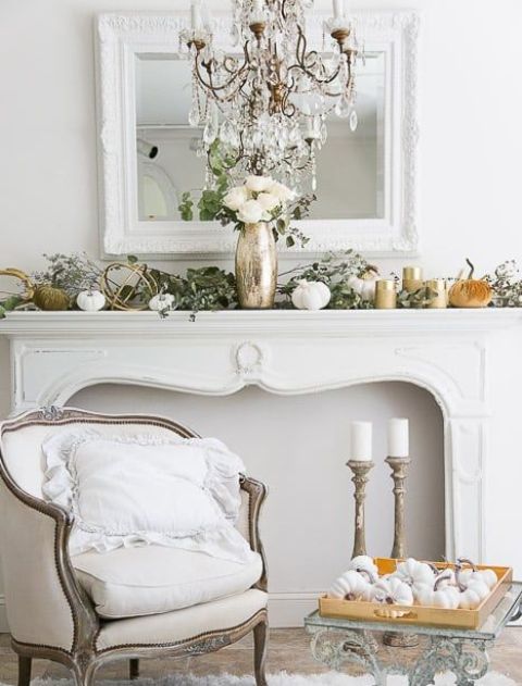 An-elegant-fall-mantel-decorated-with-fresh-greenery-fabric-and-porcelain-pumpkins-and-white-roses-in-a-metallic-vase