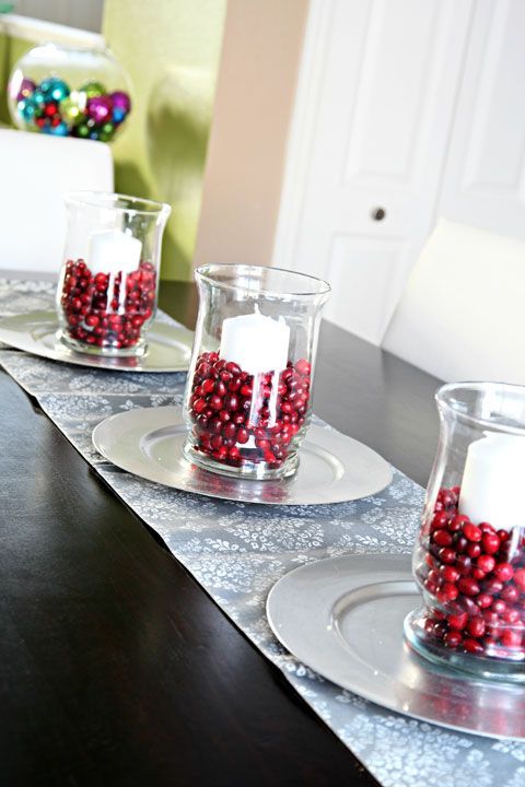 Glass-vases-with-pillar-candles-and-cranberries-for-decorating-the-table-for-the-fall