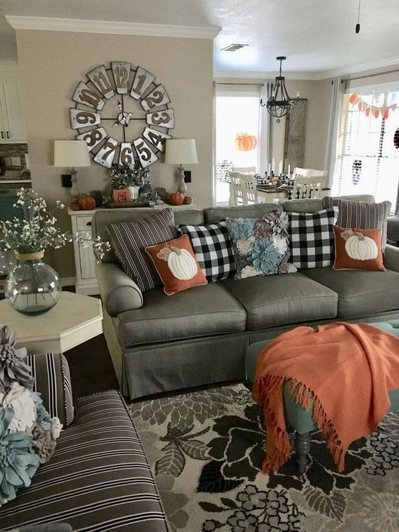 Rust-colored-textiles-and-plaid-pillows-make-this-farmhouse-living-room-very-fall-like