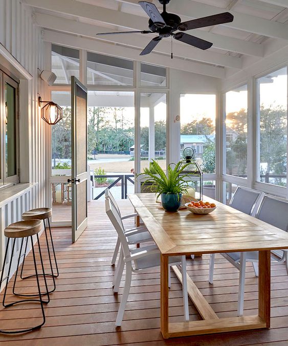 1-a-coastal-screened-porch-with-a-pass-by-window-a-wooden-dining-table-and-white-chairs-plus-views-of-the-surroundings