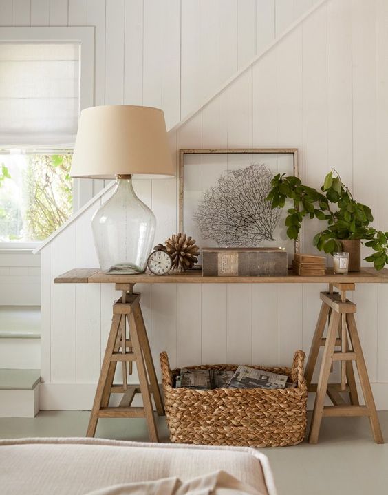 14-a-summer-console-with-a-potted-plant-a-basket-with-books-under-the-table-and-a-coral-artwork