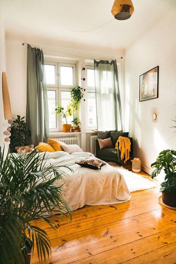 A-boho-bedroom-with-green-and-mustard-textiles-candle-lanterns-potted-plants-and-catchy-lamps