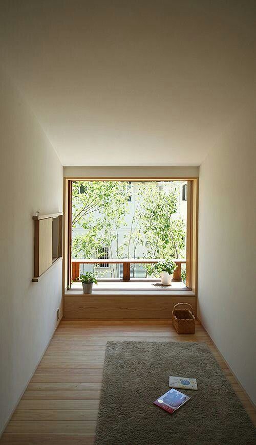 A-minimalist-meditation-space-with-a-rug-some-potted-greenery-baskets-and-a-window-with-greenery