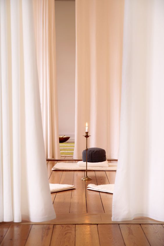 A-minimalist-meditation-space-with-curtains-rugs-pillows-and-candles-in-candle-holders