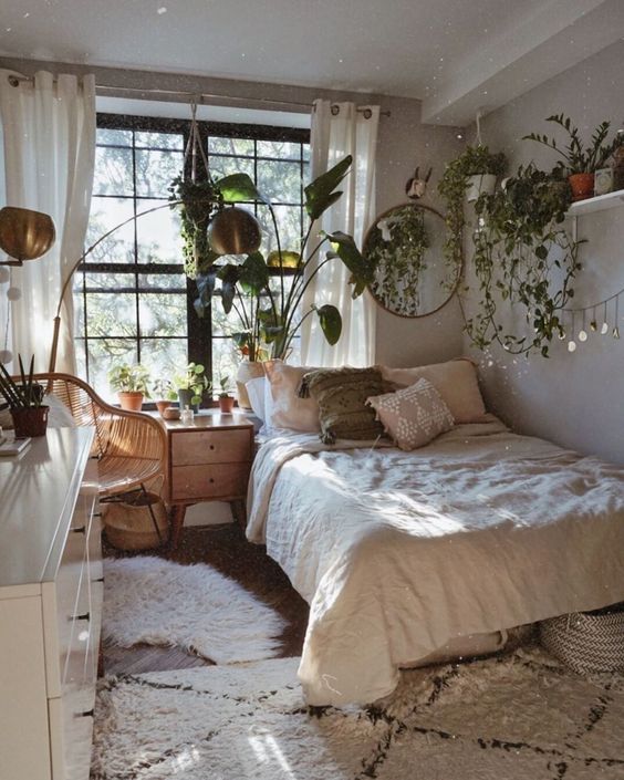 A-small-boho-bedroom-with-cascading-greenery-in-pots-wooden-furniture-and-brass-lamps