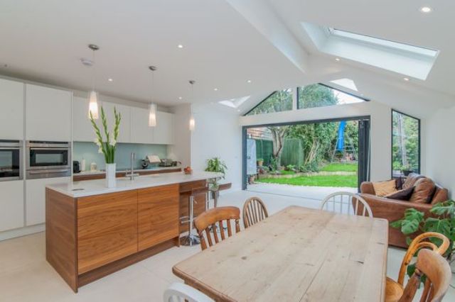 06-minimalist-white-kitchen-with-a-warm-wood-kitchen-island-and-a-light-colored-wood-dining-table