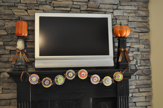 Fireplace-mantel-with-large-tv-decorated-with-candlesticks-and-banner