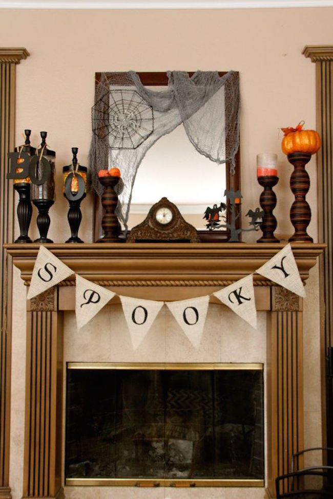 Fireplace-mantel-with-spooky-candlesticks-and-banner