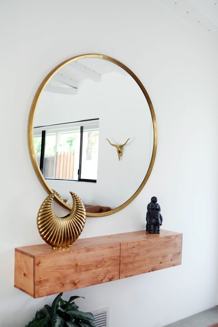 Minimal-entryway-decor-with-a-large-round-mirror-with-gold-frame