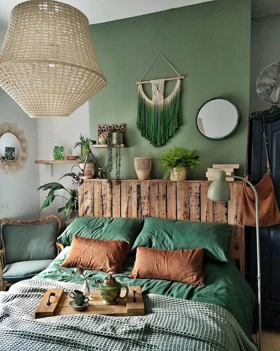 A-bold-and-chic-boho-bedroom-with-a-green-accent-wall-a-green-macrame-hanging-green-chair-and-bedding-plus-touches-of-wood-looks-lovely