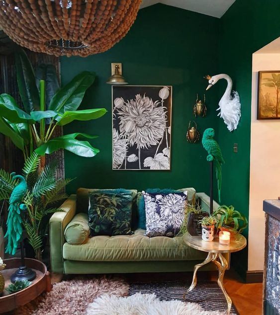 A-bold-living-room-with-emerald-walls-a-muted-grene-sofa-potted-plants-and-a-parrot-figurine-in-emerald