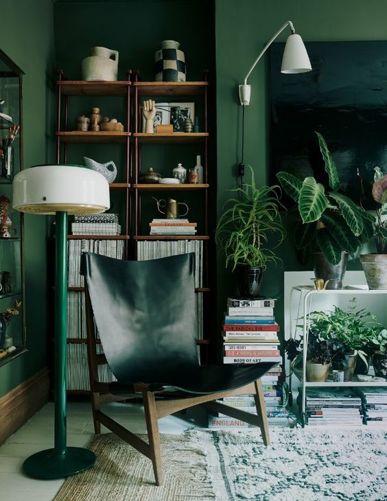 A-bold-living-room-with-green-walls-a-hunter-green-leather-chair-a-green-lamp-and-lots-of-plants-feels-comfy