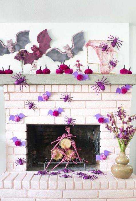 A-bright-pink-halloween-mantel-with-lots-of-paper-spiders-bats-pumpkins-and-skeleton-hands