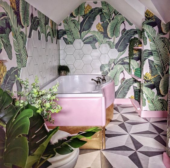 A-bright-tropical-bathroom-with-banan-leaf-wallpaper-marble-hex-tiles-a-pink-and-gold-clad-bathtub-is-lovely