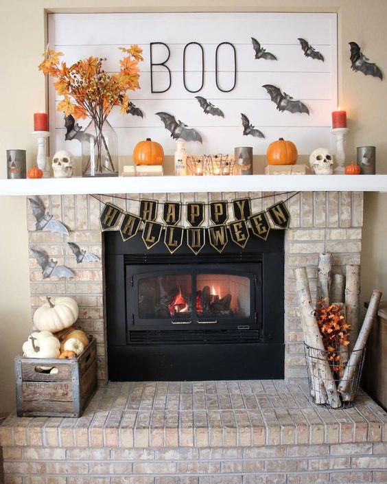 A-fabulous-halloween-mantel-with-grey-bats-pumpkins-bright-candles-branches-with-leaves-is-wow