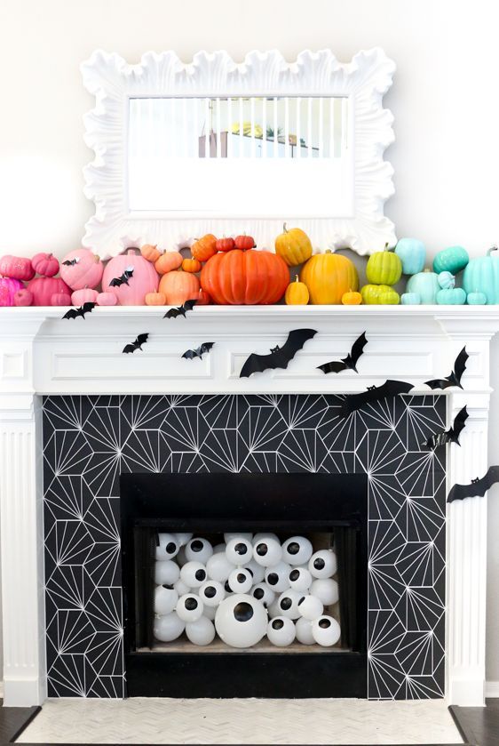 A-fireplace-filled-with-eyeballs-decorated-with-bats-and-a-mantel-with-colorful-pumpkins-for-a-fun-and-whimsy-look