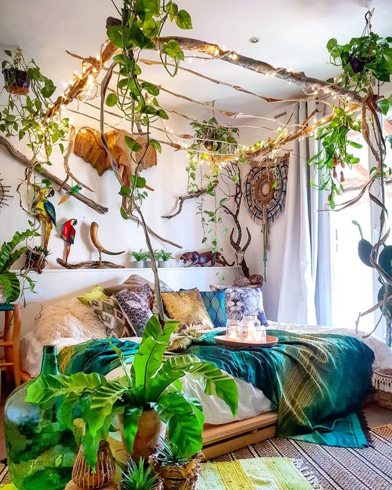 A-jungle-themed-bedroom-with-a-stick-canopy-with-lights-and-climbing-plants-bright-bedding-potted-plants-and-faux-taxidermy