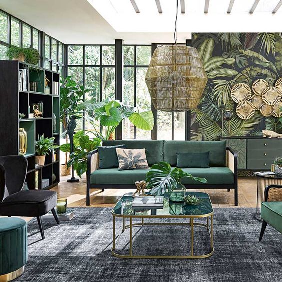 A-jungle-themed-living-room-with-a-tropical-print-wall-a-green-storage-unit-and-hunter-green-furniture-and-potted-plants