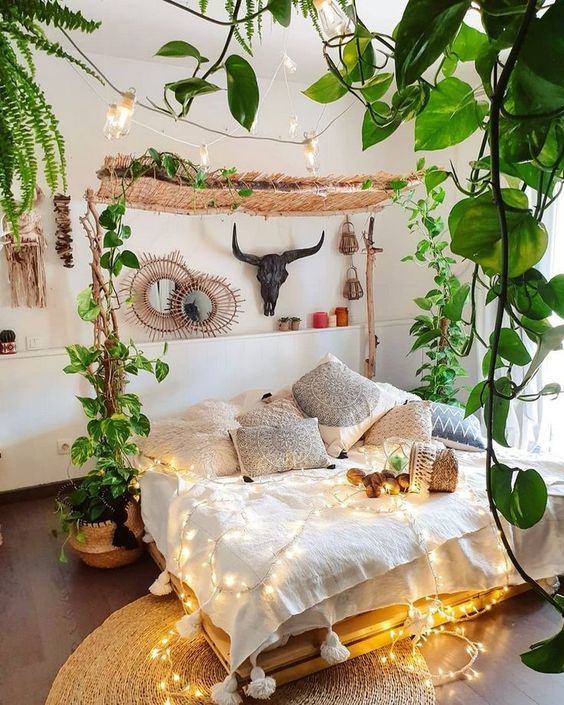 A-neutral-boho-bedroom-with-lots-of-climbing-plants-lights-and-boho-pillows-plus-mirrors