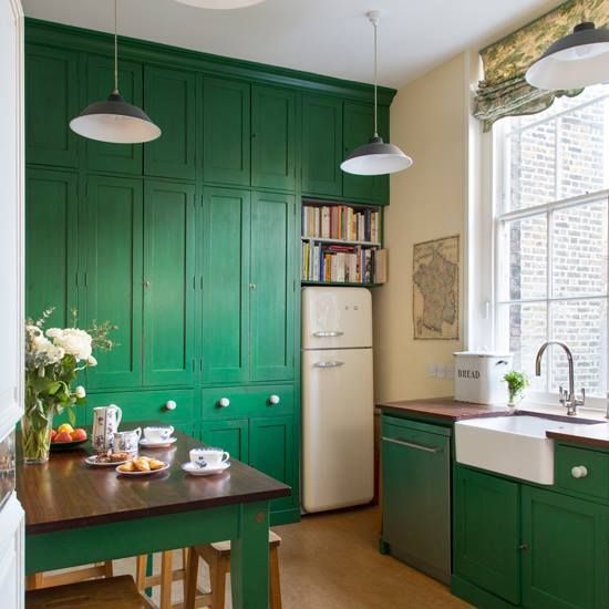 A-pretty-emerald-kitchen-with-dark-stained-wooden-countertops-pendant-lamps-and-printed-shades