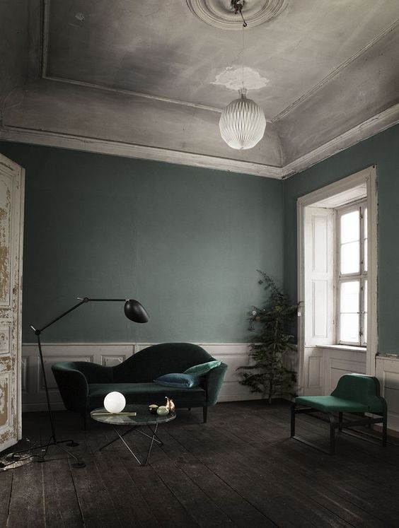 A-refined-living-room-with-grey-green-walls-hunter-green-velvet-furniture-white-paneling-and-a-chic-ceiling