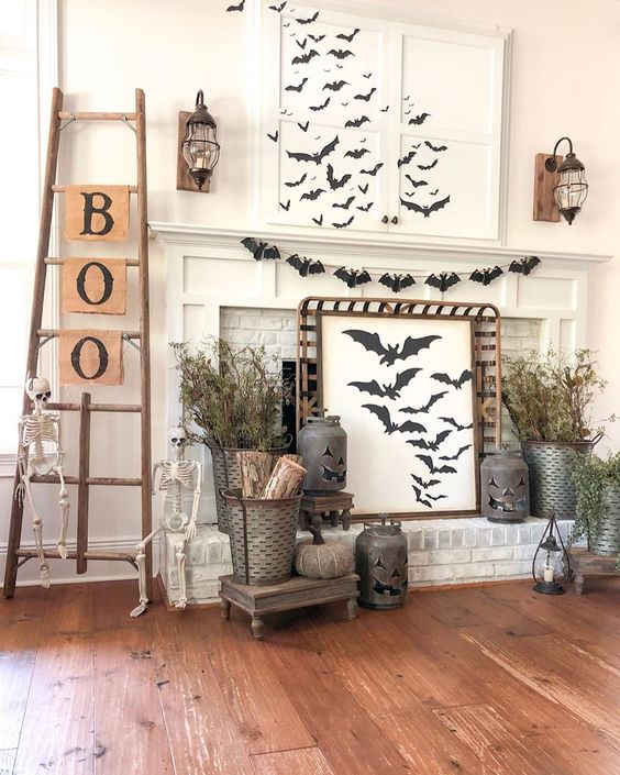 A-rustic-halloween-mantel-with-lots-of-bats-dried-branches-jack-o-lanterns-skeletons-a-ladder-with-letters